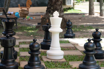 Large chess set with the white king surrounded by black pieces