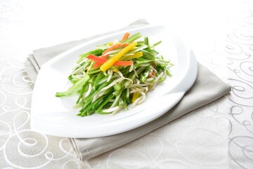 stir fried slices green dragon vegetables in soy sauce in white background asian halal menu
