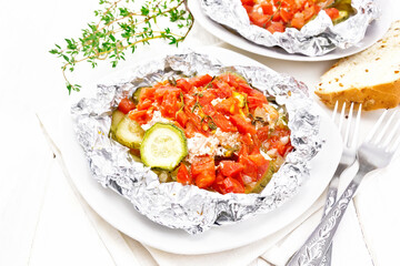 Salmon with vegetables in plate on light wooden board