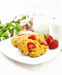 Scones with strawberry in plate on light board