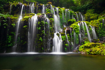 Fototapeta na wymiar Waterfall landscape. Beautiful hidden waterfall in tropical rainforest. Nature background. Slow shutter speed, motion photography. Banyu Wana Amertha waterfall, Bali, Indonesia