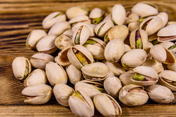 Pile of pistachio nuts on a wooden table