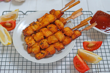 Fried fish on wooden skewers with sauce