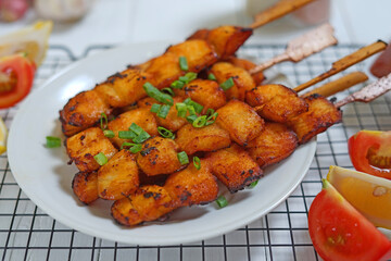 Fried fish on wooden skewers with sauce