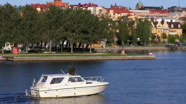 &Ouml;stersund picturesque small town on the lake Storsjon in the jamtland region. Fast boat crossing the lake during summer season with typical house on the background