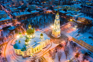 Scenic aerial view of snow covered cityscape of Penza overlooking restored architectural complex of Spassky Cathedral in winter evening, Russia.