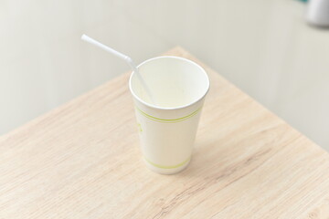 a paper cup on a wooden table