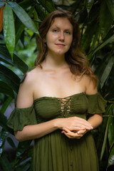 Portrait of beautiful woman in tropical rain forest. Smiling face. Green bamboo leaves in jungle. Nature concept. Bali, Indonesia