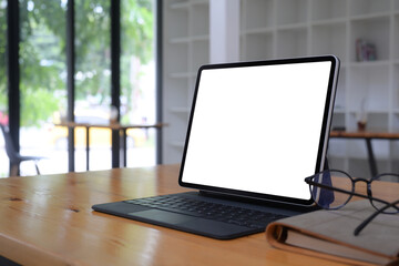 Fototapeta premium Computer tablet with lank display, glasses and book on wooden table.