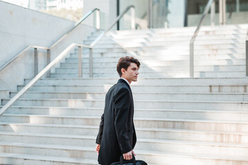 young man in casual suit walking through a place with stairs