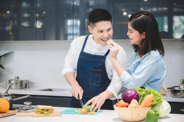 woman and man who young couple cooking food in kitchen at home, people are happy together with love about fresh vegetable lunch meal together, cheerful and smiling to healthy lifestyle