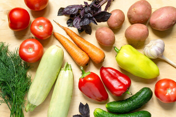 Various vegetables and herbs on light wooden background, top view