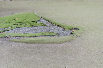 The old synthetic surface of the soccer field outdoors. Hole in