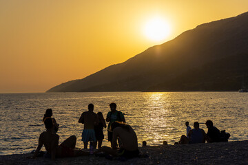 Menschen beobachten den Sonnenuntergang am Strand Zlatni Rat in der Nähe der Stadt Bol, Insel Brač, Adria, Kroatien