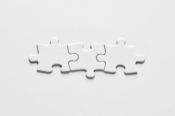 Synergy, connection, cooperation, unity or togetherness. Jigsaw puzzle pieces connected to each other.