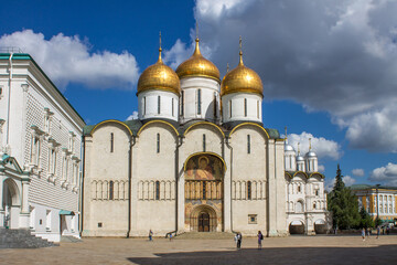 Fototapeta na wymiar MOSCOW, RUSSIA-AUGUST, 4, 2021: the white-stone Assumption Cathedral with golden domes on the Cathedral square of the Kremlin on a sunny summer day