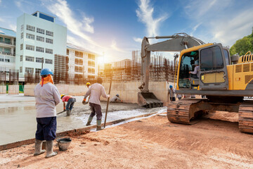 A construction worker with excavator heavy machine and cement truck for control a pouring concrete...