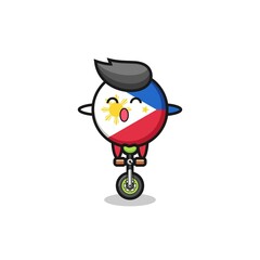 The cute philippines flag badge character is riding a circus bike