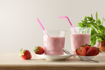 Glasses with strawberry shake on table full of fruits isolated