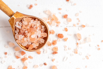 Fototapeta na wymiar Himalayan Pink Rock Salt. Mineral-rich salt from the Himalayan region. on wooden sponn on wite background