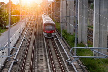 The electric train drives at high speed motion from the station  with passenger and cargo to station destination is modern trasportation concept with sun light sky background.