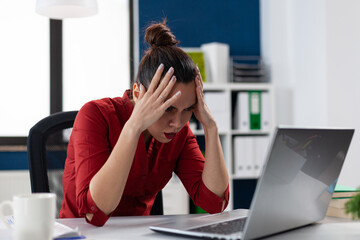 Frustrated businesswoman having problem with broken slow laptop, in corporate workplace. Stressed...