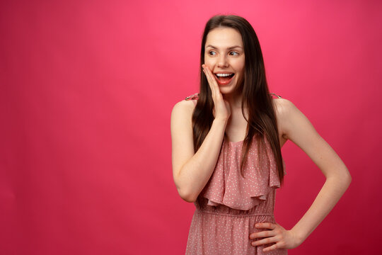 Shocked and surprised girl screaming against pink background