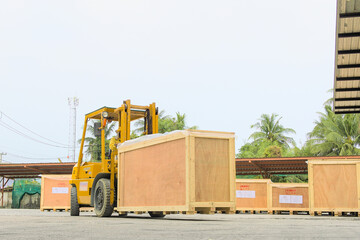 Driver maneuvering his forklift while lifting a wooden box  © McOwenlevi