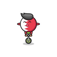 The cute bahrain flag badge character is riding a circus bike
