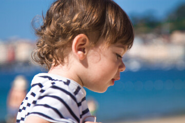 portrait of little boy in striped t-shirt on the beach