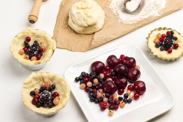 Frozen berries in plate. Dough and berries in baking cup.