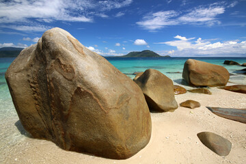 Fototapeta na wymiar a rocky beach next to a tropical body of water