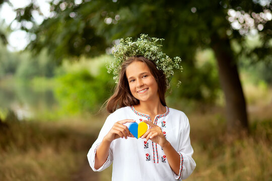Girl in embroidery adn flower wreath with yellow and blue heart. Love Ukraine concept. Independence, flag, constitution day of Ukraine - Powered by Adobe