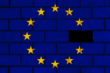 The European Union with Euro symbol points economic crisis.  European Union Flag on brick wall. Flag incomplete or partially destroyed.
