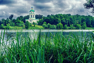Pond and church bell tower on a cloudy day