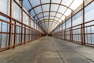 Tunnel Symmetrical Walkway with tiles on floor. Crossing the railway