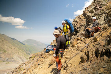 Mountain tourists are sitting on a rock. Climbing Kazbek from the north, from the side of Russia.