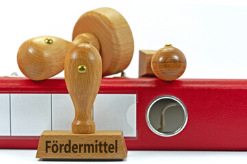 Holzstempel mit der Aufschrift Fördermittel