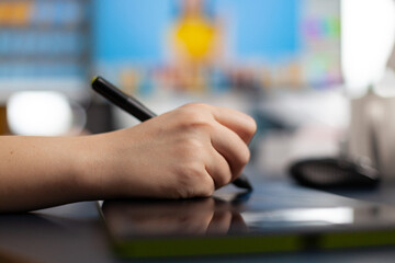 Close up of designer retoucher photographer hand editing customer photo using computer with two displays and stylus pen. Graphic editor retouching pictures drawing on graphic tablet in studio