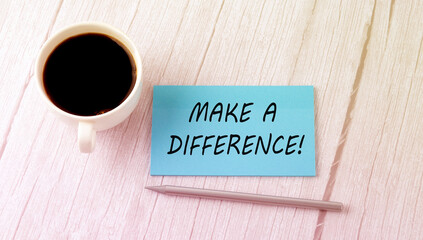 MAKE A DIFFERENCE text on the blue sticker with cofee and pen