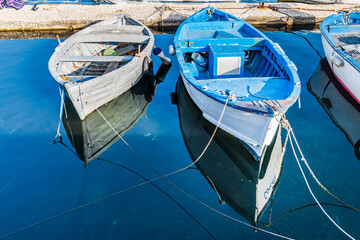 Fototapeta na wymiar Strolling along the streets of Gallipoli. Boats and places of a magical Salento