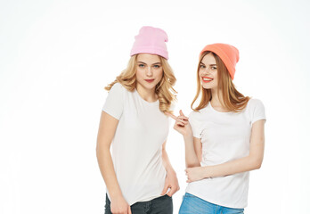 two cute girlfriends in hats hugging friendship close-up