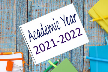 2021 2022 academic year. blue, yellow, orange and blue notebooks. text on a white sheet of notepad...