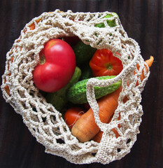 eco grid with vegetables for a trip to the supermarket with tomatoes cucumbers carrots and onions .