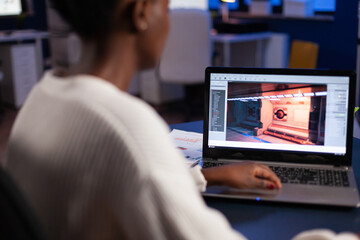 African american game developer testing new game working late at night in creativity agency company. Tired creator designer developing online video games on pc using modern production technology