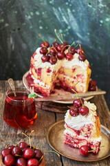 Cherry cake. Yeast bun with cherries and cream. A piece of cake. Top view, wooden and blue background.