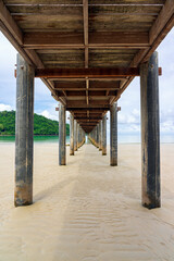 View under wooden pier on sand beach