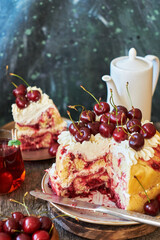 Cherry cake. Yeast bun with cherries and cream. A piece of cake. Top view, wooden and blue background.
