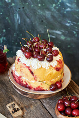Cherry cake. Yeast bun with cherries and cream. Top view, wooden and blue background.