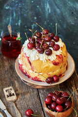 Cherry cake. Yeast bun with cherries and cream. Top view, wooden and blue background.